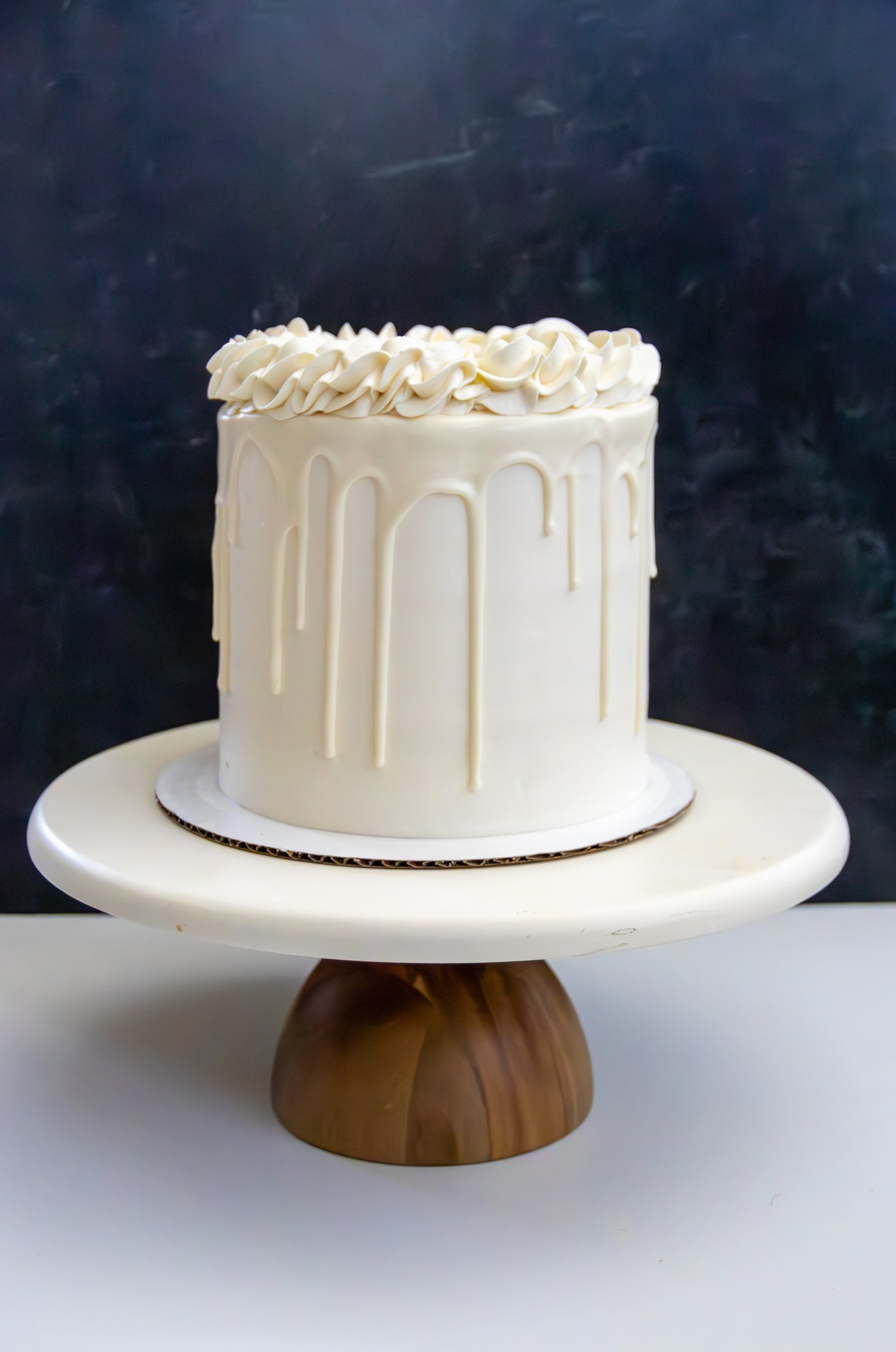 White drip cake on a stand
